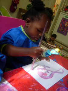 Child painting in the Busy Bees room at Early Learners' Nursery School, Leicester